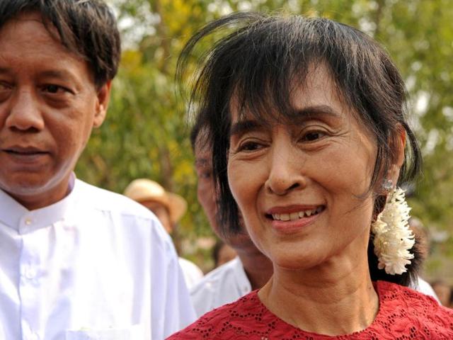 Myanmar opposition leader Aung San Suu Kyi smiles as she leaves after visiting a polling station in the constituency where she stands as a candidate in Kawhmu . Voting began in Myanmar elections seen as a test of the government's budding reforms, with opposition leader Aung San Suu Kyi standing for a seat in parliament for the first time. AFP PHOTO/Christophe ARCHAMBAULT