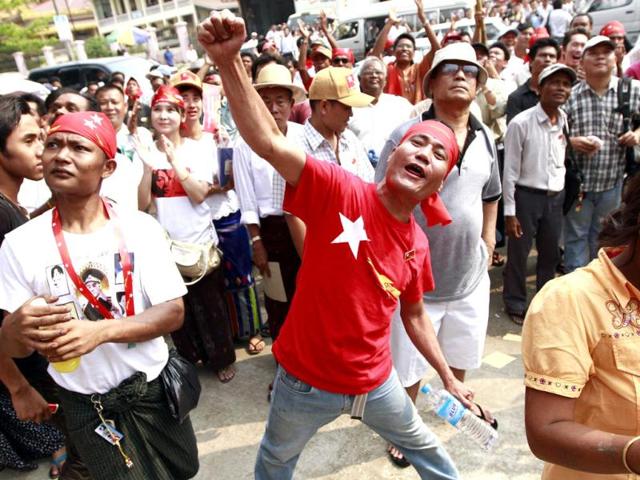 A supporter of Myanmar's democracy leader Aung San Suu Kyi's National League for Democracy party, center, shouts slogans while others wait for the election result for the country's by-elections outside the party headquarters in Yangon, Myanmar. (AP Photo/Khin Maung Win)