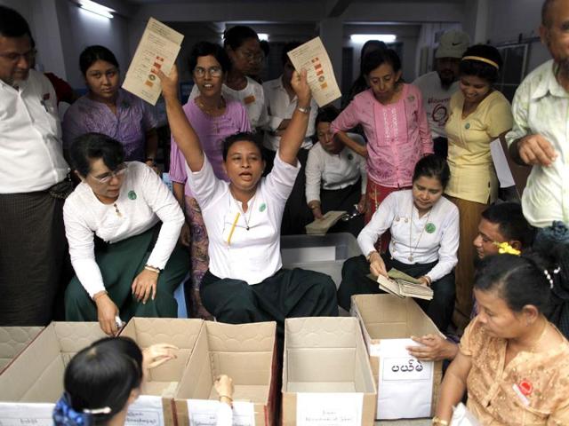 An election official shows ballots with votes for Aung San Suu Kyi's National League for Democracy as votes are counted in Yangon. REUTERS/Damir Sagolj