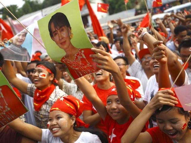 Supporters of the National League for Democracy (NLD) party cheer holding a portrait of Myanmar pro-democracy leader Aung San Suu Kyi as they watch increasing votes on a screen at the roof of the NLD office in Yangon. Myanmar voted on Sunday in its third election in half a century. REUTERS/Staff