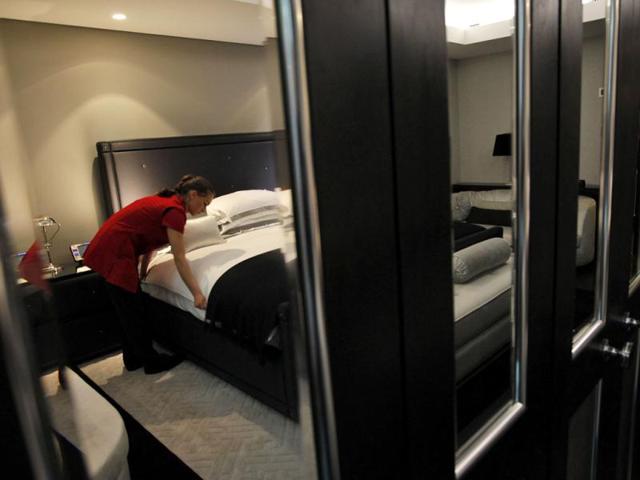 A maid adjusting the pillows in one of the five bedroom luxury penthouse apartments available for hire during the London 2012 Olympics for some 11,000 British pounds a night - and includes a maid a butler and and Aston Martin car. AP Photo/Alastair Grant