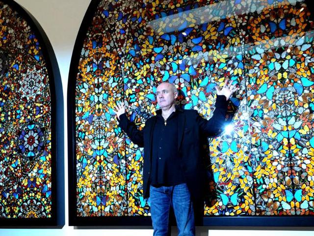 British artist Damien Hirst poses for photographers with a creation entitled Doorways to the Kingdom of Heaven 2007 during the opening of his solo exhibition showcasing work spanning over two decades at the Tate Modern in central London. AFP Photo/Carl Court