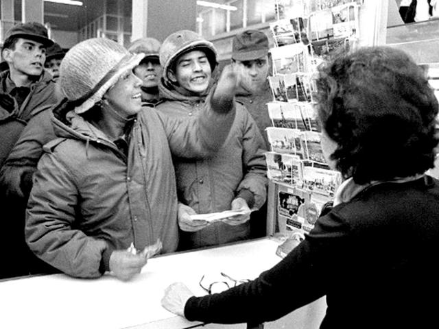 Argentine soldiers buy postcards at a souvenir shop in Stanley, 13 April 1982. AFP/Daniel Garcia