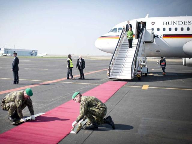 German Chancellor Angela Merkel watches Czech soldiers fixing the red carpet upon her arrival at the airport in Prague. Merkel is on a one-day official visit to the Czech Republic. (AP Photo)