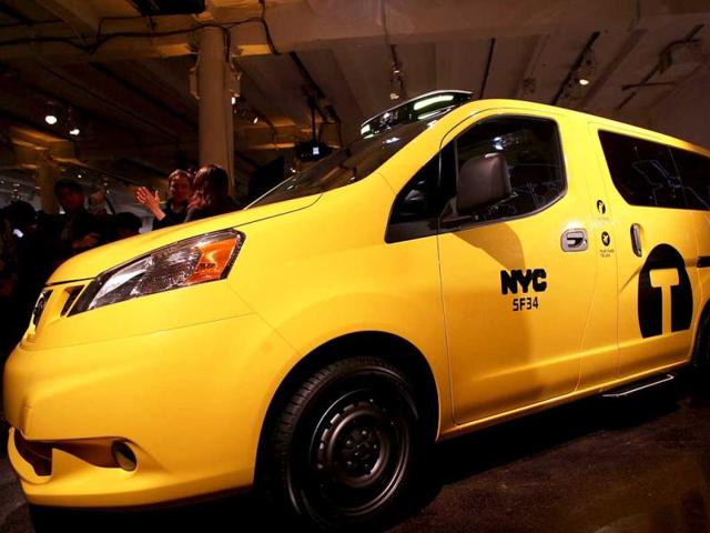 People look at the new New York City taxi which is designed by the Nissan Motor Co. at an official unveiling in New York City. The new taxis, which will start appearing on the streets of New York next year, include front and rear-seat occupant curtain airbags, a window on the roof, backseat cellphone charging and USB ports and passenger reading lights. (AFP Photo)