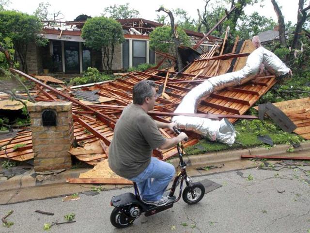 Sean Lanham inspects his neighborhood on a scooter after an apparent tornado hit near Bardin Road and and Spring Creek Road in Arlington, Texas. (AP Photo)
