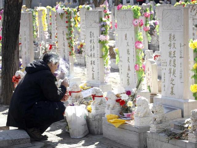A local Chinese burns incense at a cemetery during Qingming Festival in Beijing, China. Qingming festival, also known as the Grave Sweeping Day, is a day when Chinese around the world remember their dearly departed and take time off to clean up the tombs and place flowers and offerings. (AP Photo)