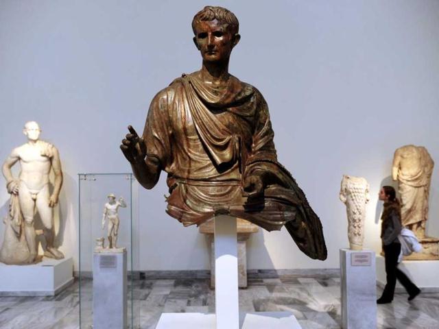 A visitor looks at antiques at the National Archeological museum in Athens. Faced with massive public debt as it moves into a fifth year of recession, Greece is finding that its fabled antiquity heritage is proving a growing burden. AFP Photo/Aris Messinis