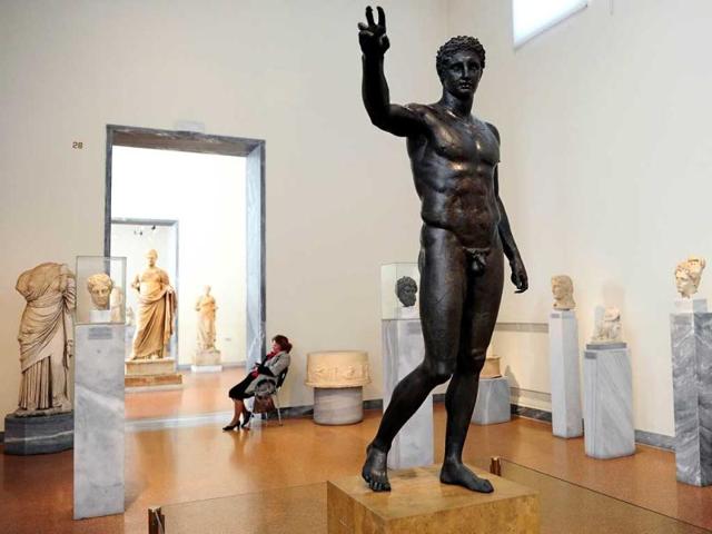 An employee sits at the National Archeological museum in Athens. Faced with massive public debt as it moves into a fifth year of recession, Greece is finding that its fabled antiquity heritage is proving a growing burden. AFP Photo/Aris Messinis