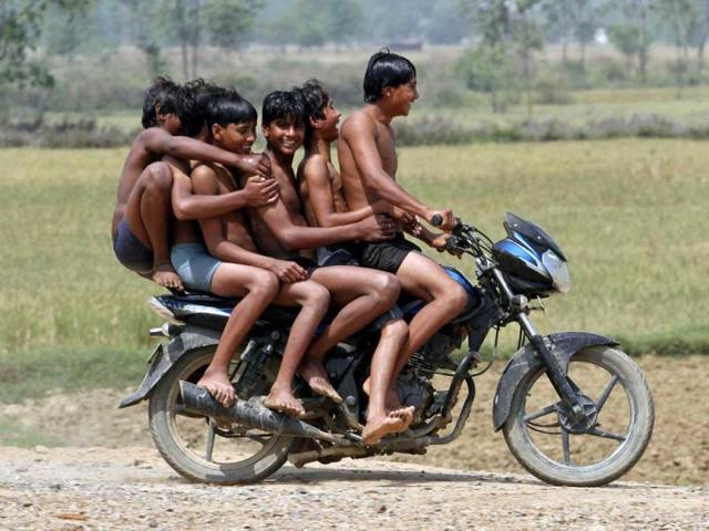 Boys ride a motorbike on their way back home after taking a bath in a canal at Chachura village, in the northern Indian state of Uttar Pradesh. REUTERS/Parivartan Sharma