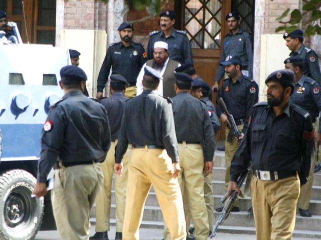 Police escort Hafiz Saeed as he leaves after an appearance in court in Lahore March 9, 2009. Reuters/Mohsin Raza