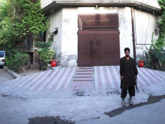 A private security guard stands outside the residence of Hafiz Saeed, the head of Jamaat-ud-Dawa and founder of Lashkar-e-Taiba, in Lahore. Reuters/Mohsin Raza