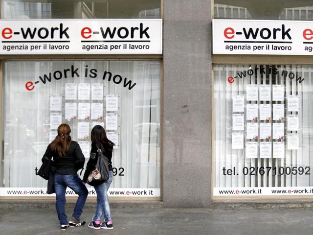 People check job offers outside a recruitment agency in downtown Milan. Italy's headline jobless rate has been running below the euro zone average, but analysts say the real challenge for Italy is to increase its chronically low rates of employment and participation in the labour market, which are among the lowest in the industrialized world, especially among women, the young and the elderly. REUTERS/Alessandro Garofalo