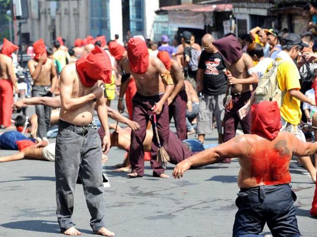 Penitents flagellate themselves as part of Lenten observance in Manila. AFP Photo/Ted Aljibe.
