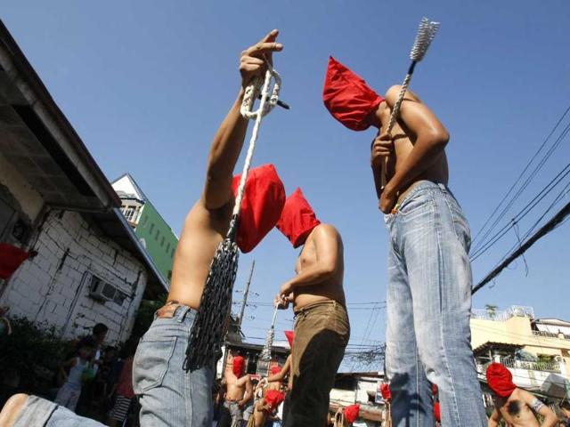 Hooded penitents flagellate themselves in a ritual to atone for their sins in observance of Holy Week at Mandaluyong city, east of Manila, Philippines. AP Photo/Bullit Marquez