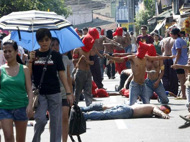 Hooded penitents lay prone on the pavement during flagellation ritual to atone for their sins in observance of Holy Week at Mandaluyong city, east of Manila, Philippines. Such practice is rejected by the Catholic church. AP Photo/Bullit Marquez