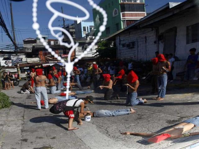 Hooded penitents are reflected on a car windshield with a Holy Rosary sticker as they flagellate themselves in a Holy Week ritual to atone for their sins at Mandaluyong city, east of Manila, Philippines. AP Photo/Bullit Marquez