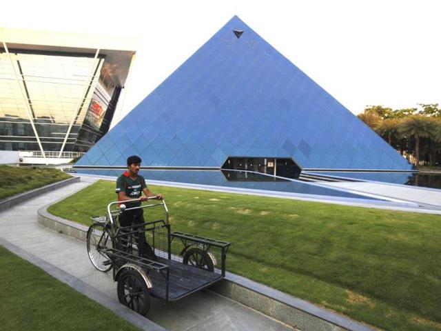 A-man-pushing-a-tricycle-cart-walks-in-front-of-a-pyramid-shaped-building-made-out-of-glass-in-the-Infosys-campus-at-Electronics-City-in-Bangalore-India-s-IT-industry-with-Bangalore-firms-forming-the-largest-component-is-now-worth-an-annual-100-billion-and-growing-14-percent-per-year-Reuters A-man-pushing-a-tricycle-cart-walks-in-front-of-a-pyramid-shaped-building-made-out-of-glass-in-the-Infosys-campus-at-Electronics-City-in-Bangalore-India-s-IT-industry-with-Bangalore-firms-forming-the-largest-component-is-now-worth-an-annual-100-billion-and-growing-14-percent-per-year-Reuters