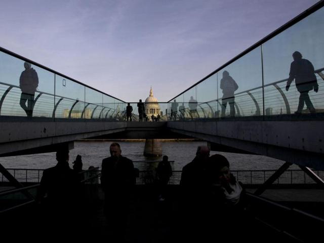 St Paul's Cathedral is seen during sunrise as pedestrians walk across the Millennium Bridge in the City of London. Reuters/Stefan Wermuth, Files