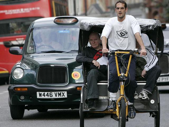 A rickshaw driver rides through the London traffic. Reuters/Luke MacGregor, Files