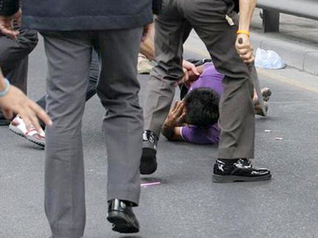 Thai policemen electroshock Sakdawut Hamsiri, 30, in purple shirt, with a Taser after he held a knife against his wife Thawee Naiyanit on a street in Bangkok, Thailand. The 6-hour knifepoint hostage ended when the police used a Taser gun to electroshock him and took him to the police station. Police said the man was under the influence of drugs. (AP Photo/Sakchai Lalit)