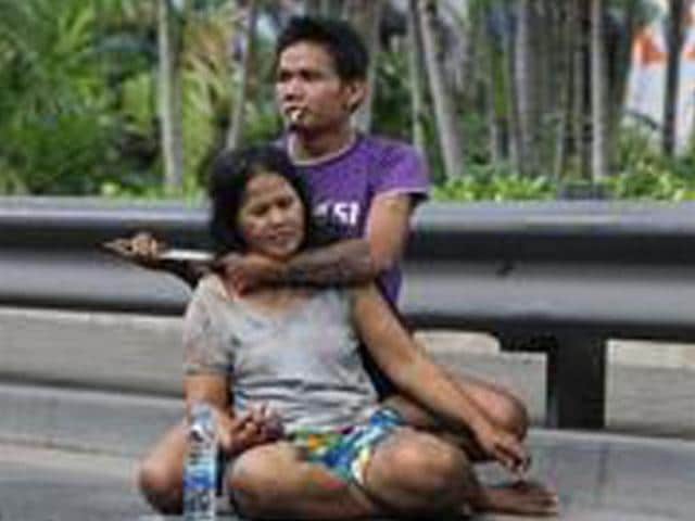 Sakdawut Hamsiri, 30, holds a knife against his wife Thawee Naiyanit on a street in Bangkok, Thailand. The 6-hour knifepoint hostage ended when the police used a Taser gun to electroshock him and took him to the police station. Police said the man was under the influence of drugs. (AP Photo/Sakchai Lalit)
