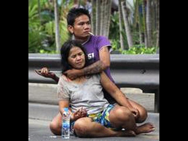 Sakdawut Hamsiri, 30, holds a knife against his wife Thawee Naiyanit on a street in Bangkok, Thailand. The 6-hour knifepoint hostage ended when the police used a Taser gun to electroshock him and took him to the police station. Police said the man was under the influence of drugs. (AP Photo/Sakchai Lalit)