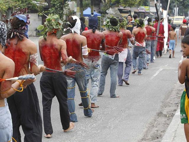Hooded barefoot penitents perform self-flagellation to atone for their sins in San Fernando, Pampanga in northern Philippines. Reuters/Erik De Castro