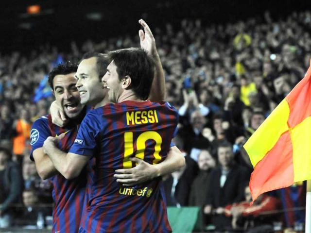 FC Barcelona's Andres Iniesta, center, is congratulated by teammates Lionel Messi from Argentina, right, and Xavi Hernandez after scoring against AC Milan during their Champions League second leg, quarterfinal soccer match, at Camp Nou stadium in Barcelona, Spain. (AP Photo)