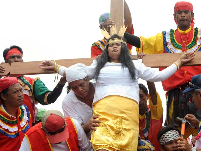 Christian religious fanatic Precy Valencia is nailed to a cross before a large crowd of spectators on Good Friday in Paombong town, Bulacan province. Roman Catholic fanatics in the Philippines had themselves nailed to the cross in a bloody display of religious frenzy as the Christian world marked the day Jesus was crucified. AFP/Jay Directo