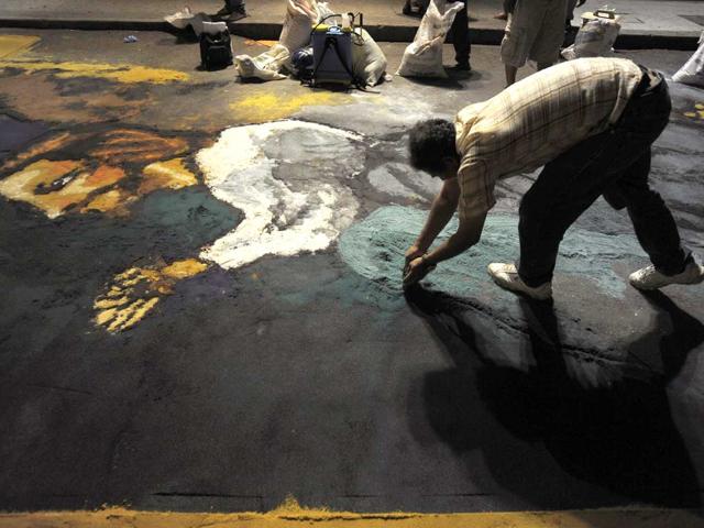 A man works on an image of Jesus Christ while making a sawdust carpet on a road in Tegucigalpa. Reuters/Jorge Cabrera