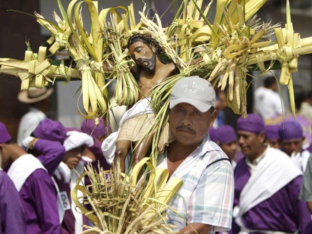 A man carrying a statue of Jesus Christ participates in a Holy Week procession in Izalco, some 40 miles west of San Salvador, El Salvador. (AP Photo/Luis Romero)