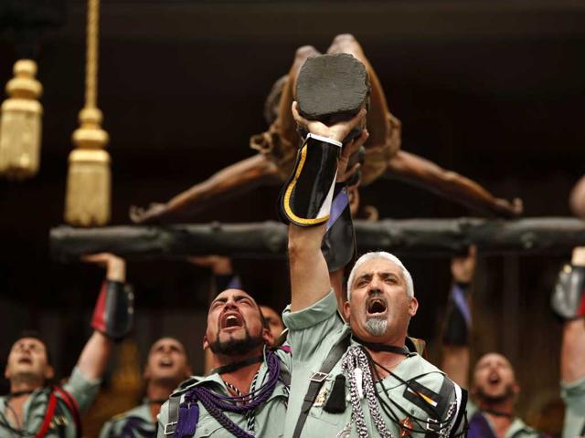 Spanish legionnaires sing an anthem as they carry a statue of the Christ of Mena outside a church during a ceremony before they take part in the Mena brotherhood procession in Malaga, southern Spain. Reuters/Jon Nazca