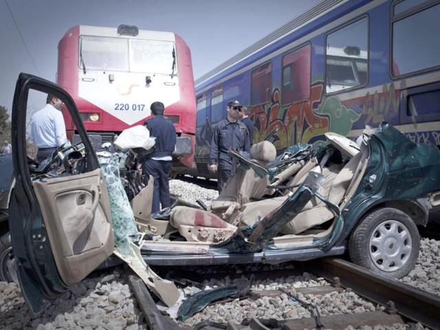 Rescuers stand next to the wreckage of a car that was hit by a train in an accident that killed four people at Kryoneri, on the northern fringes of Athens. AP/Michail Michailidis