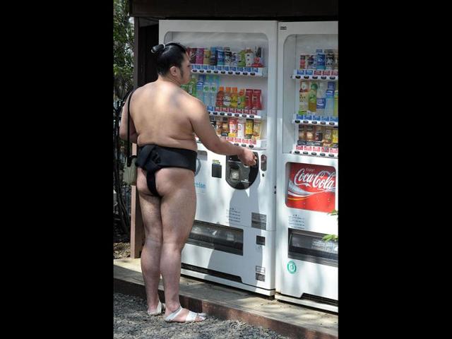 A sumo wrestler buys a drink as he attends an exhibition at Yasukuni shrine in Tokyo. AFP/Richard A Brooks