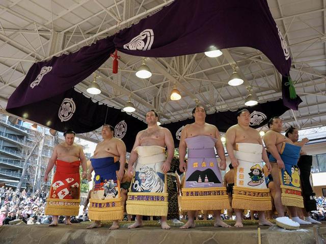 Sumo wrestlers line up along the ring before the start of their bouts during a sumo exhibition at Yasukuni shrine in Tokyo. AFP/Richard A Brooks