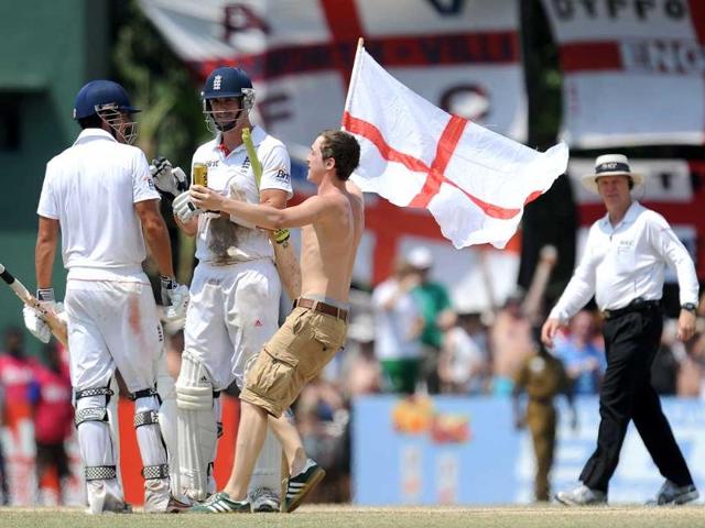 England cricketers Kevin Pietersen (C) and Alastair Cook (L) are congratulated by a fan as they celebrate victory during the final day of the second and final Test match against Sri Lanka at the P Sara Oval crickrt Stadium in Colombo. England defeated Sri Lanka by 8 wickets to level the series 1-1 and retain their number one Test ranking. AFP Photo/ Lakruwan Wanniarachchi