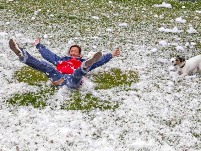 A woman plays with her dog amid feathers that are strewn across a lawn after a pillow fight flashmob at the Brandenburg Gate that was organized over Facebook in Berlin. Reuters/Thomas Peter