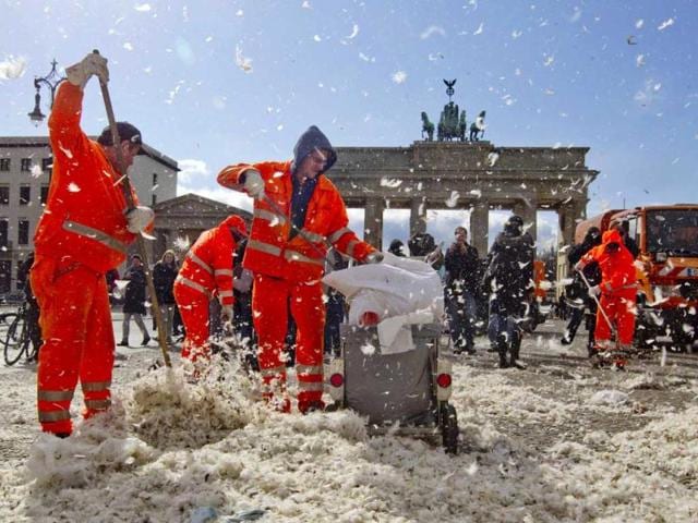 Municipal workers clean up feathers after a pillow fight flashmob at the Brandenburg Gate that was organized over Facebook in Berlin. Reuters/Thomas Peter