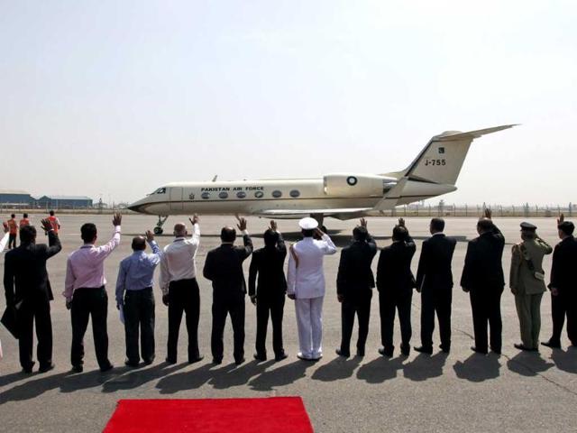 Pakistan and Indian officials wave at the plane carrying Pakistan President Asif Ali Zardari as it prepares to take off from Palam Airfield in New Delhi for Jaipur. AP Photo/Saurabh Das