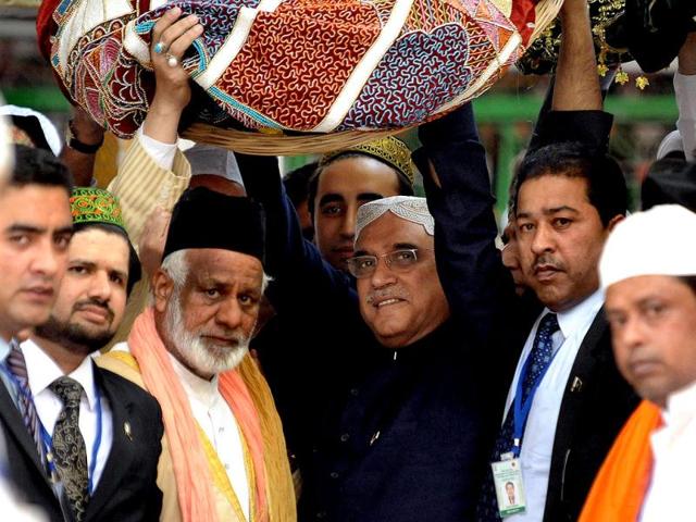 Pakistan's President Asif Ali Zardari carries a traditional offering on his head at the renowned 13th century shrine of Sufi saint Khwaja Moninuddin Chisti in Ajmer. AFP