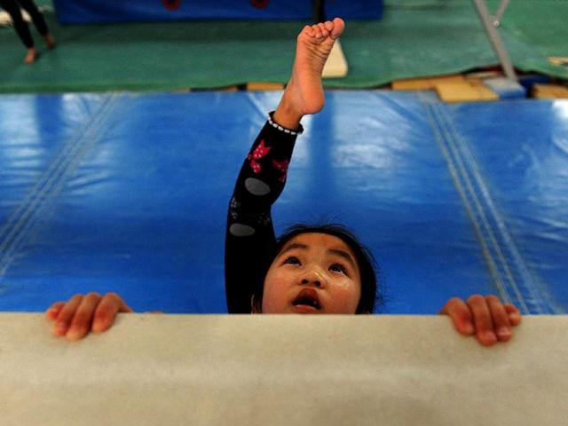 Young Chinese gymnast trains at a special sport school in Hefei, east China's Anhui province. Potential gymnasts embark on a gruelling schedule which aims to create champions. AFP photo
