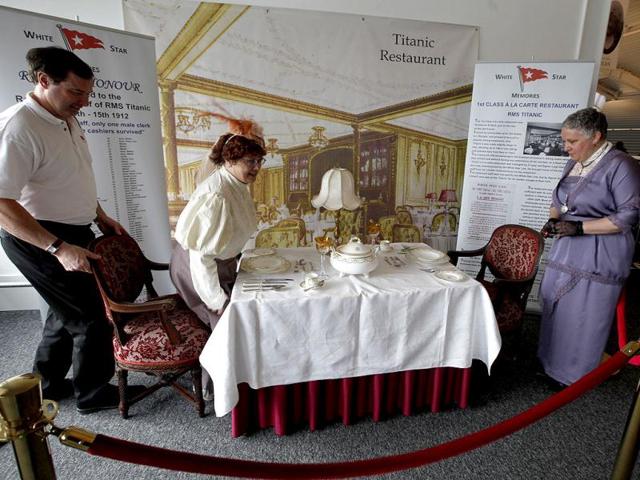 Sisters Terri Williamson, left and Tracie Brelsford from Washington state in the US pose for their photograph as they sit in a mock up of a first class dinning table from the Titanic in the check in area for the MS Balmoral's Titanic memorial cruise in Southampton, England. With 1,309 passengers aboard, the MS Balmoral will follow the same route as the Titanic. Organisers are trying to recreate the onboard experience minus the disaster from the food to a band playing music from that era. (AP Photo)