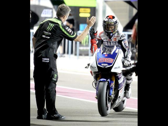 Jorge Lorenzo of the Yamaha Factory Racing team celebrate with his team members after gaining pole position in the qualifying session for the Motorcycle Grand Prix of Qatar at al Losail International Circuit in Doha. AP