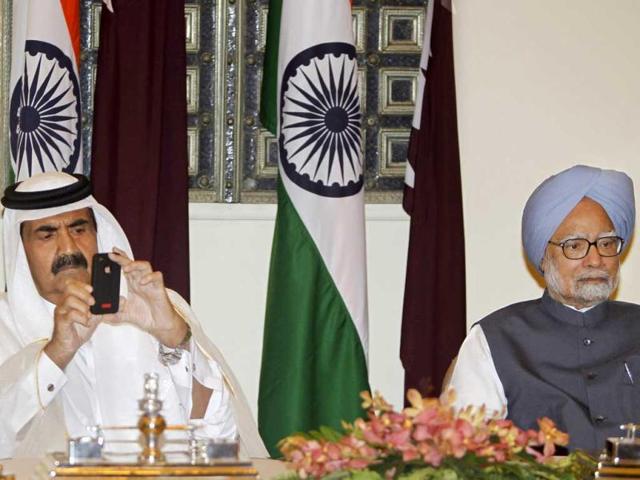 Emir of Qatar, Sheikh Hamad bin Khalifa Al Thani uses his phone to take video of the signing of agreements between India and Qatar as he sits next to Prime Minister Manmohan Singh at Hyderabad House in New Delhi. AP/Mustafa Quraishi