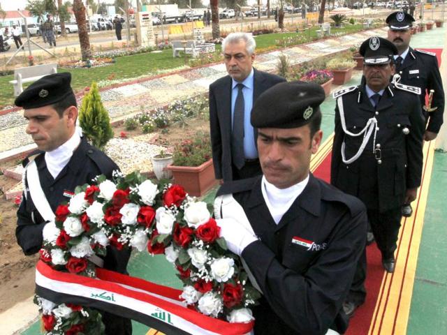 Iraqi oil minister Abdelkarim al-Luaybi (2nd row C) walks on a red carpet at the Dora Oil refinery on the outskirts of the Iraqi capital Baghdad, before laying a wreath at the memorial for oil installation security forces who died during the fall of Baghdad in the 2003 US-led invasion of Iraq, during a ceremony on April 9, 2012, to mark the invasion's ninth anniversary. AFP Photo/Sabah Arar