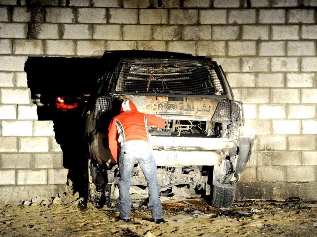 A policeman inspects a police car, which was driven into a wall after the driver lost control during an attack by anti-government protesters with Molotov cocktails, in Sitra, south of Manama. Reuters photo