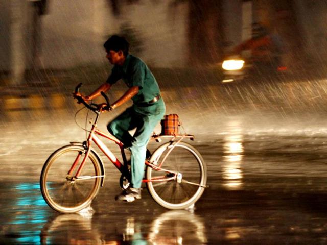 A man cycles through heavy downpour in New Delhi. HT Photo/Jasjeet Plaha