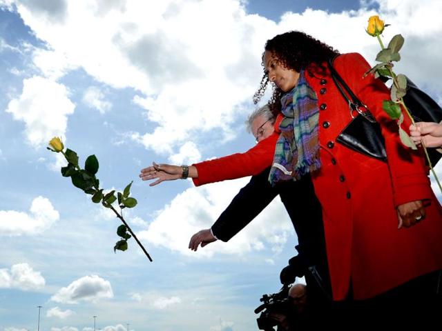 A woman throws a rose into the sea at berths 43/44 from where the RMS Titanic set sail on its ill-fated maiden voyage 100 years ago at Southampton dock. (AFP photo/ Ben Stansall)