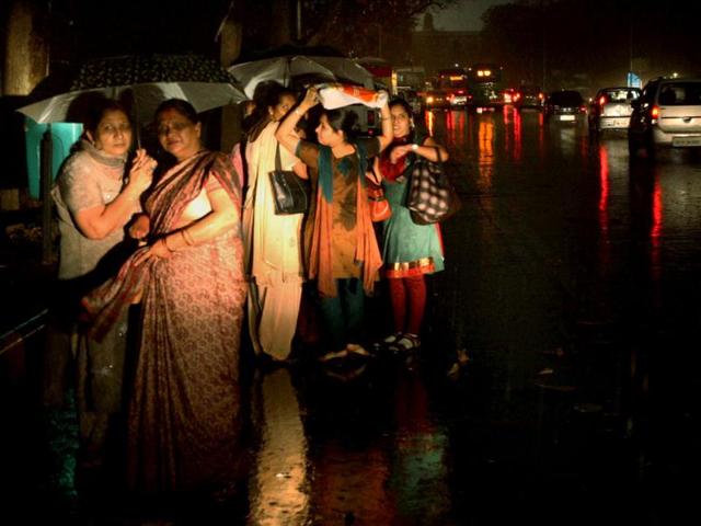 Commuters wait for bus at a stop during a thunderstorm coupled with showers in New Delhi. PTI Photo/Subhav Shukla